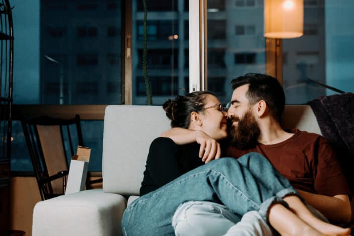 Couple intimately cuddling on the sofa.