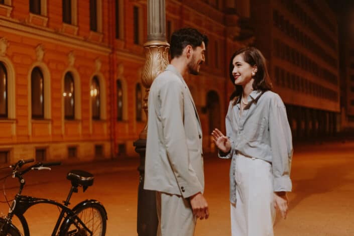 Couple talking outdoors at night.