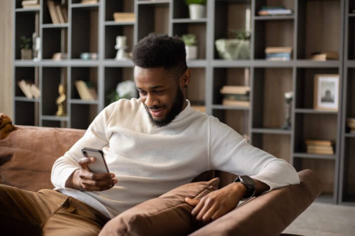 Man delightedly reading a message from his phone.