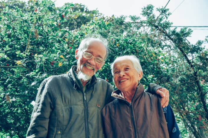 An old couple smiling at the camera