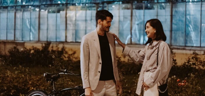 Couple Smiling While Woman Touches The Man's Shoulder