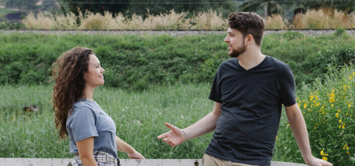 couple talking to each other in the middle of the field