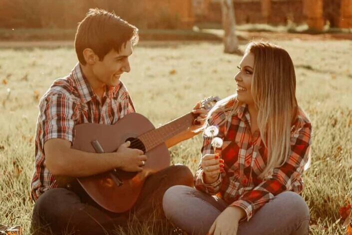 Man Playing The Guitar For A Woman