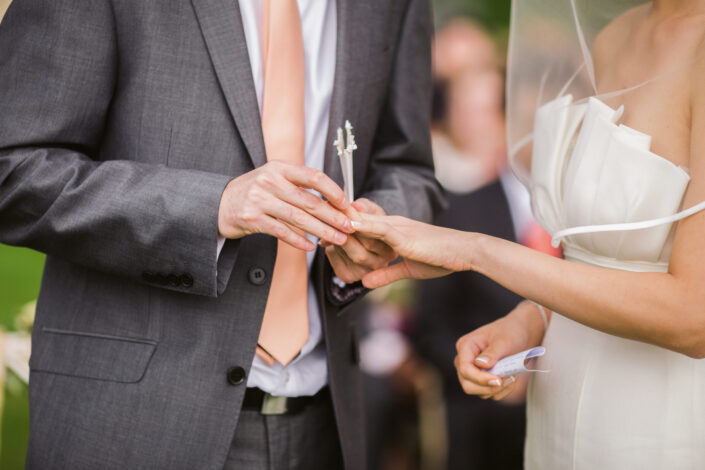 Man Putting On His Wife's Wedding Ring At Their Wedding