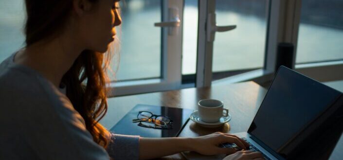 woman sitting beside table using laptop