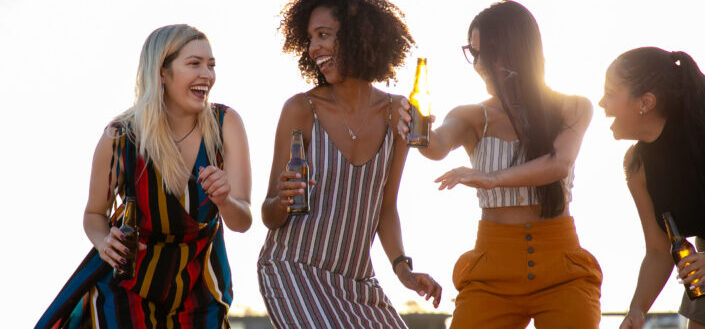 Group of girl friends catching up while happily drinking beer 