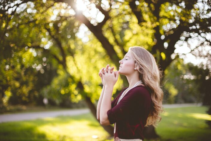 Woman meditating under the shade of a huge tree