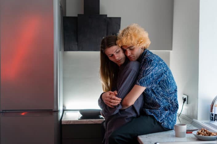 Man Sitting on Kitchen Counter Hugging His Partner