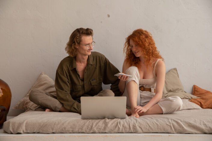 Couple talking to each other while sitting on their bed