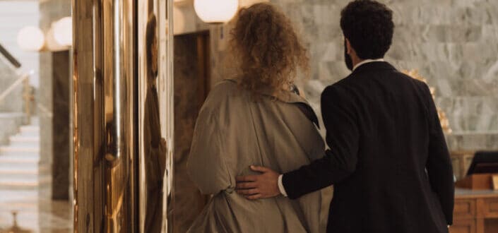 A Gentleman and a Woman Walking Inside a Hotel