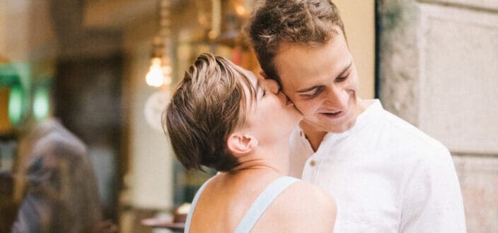Pretty Woman Kissing a Man on The Cheek