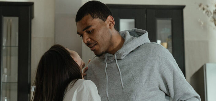Man in Gray Hoodie Kissing His Woman