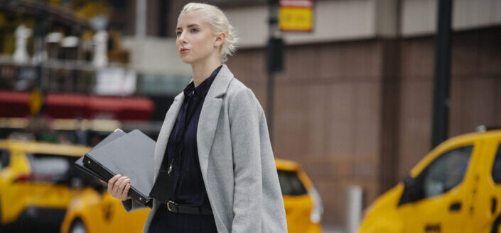 Professionally dressed woman walking on a busy street
