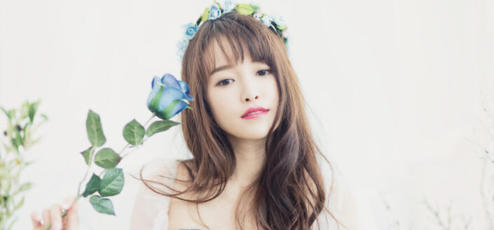 Woman Wearing a Flower Crown and Holding a Blue Rose