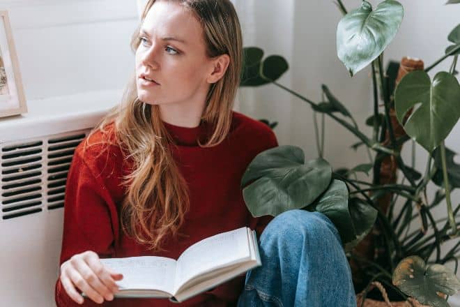 serious-young-female-looking-away-while-reading-book-sitting-on-floor-near-window-stockpack-pexels - How to figure out what you want to do in your life - Main