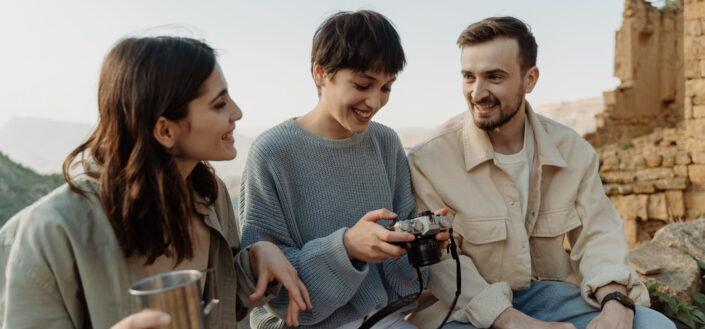 A group of people sitting on rocks with a camera