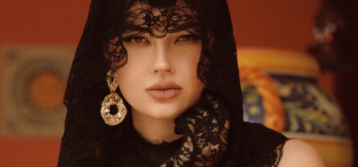 An elegant woman in black dress with black veil and gloves