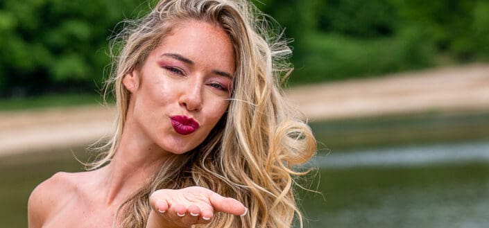 Charming woman in dress sending air kiss