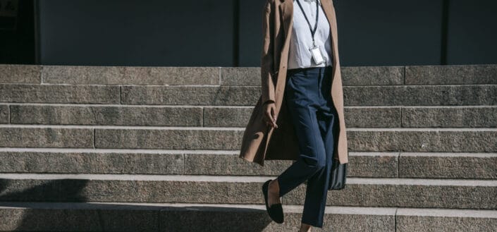 Crop black businesswoman walking down steps