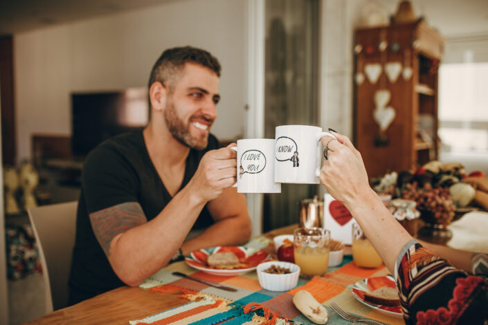 Man in black crew neck t shirt holding white ceramic mug