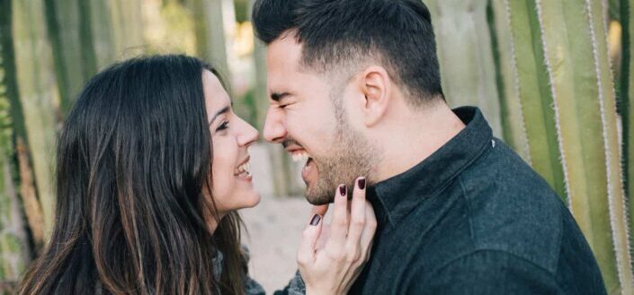Man laughing while facing a woman