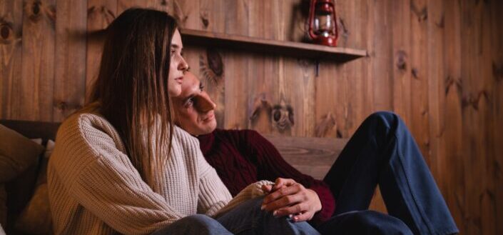woman in white and black striped long sleeve shirt sitting beside man in black sweater