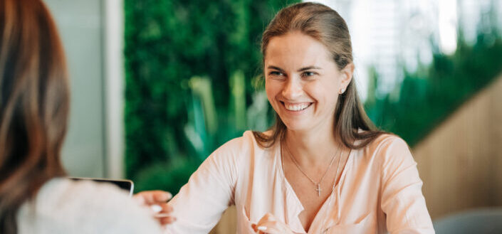 young-happy-woman-smiling-and-talking-with-colleague-stockpack-pexels