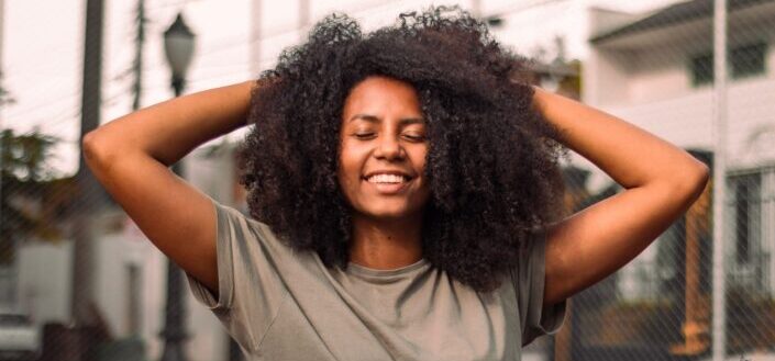 girl messing her curly hair happily