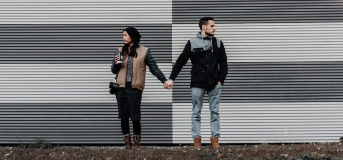 couple holding hands while facing opposite direction
