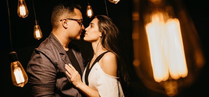 couple flirting under light bulbs