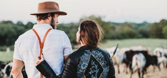 A couple walking with the cows