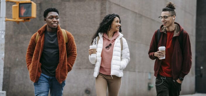friends smiling while walking on street