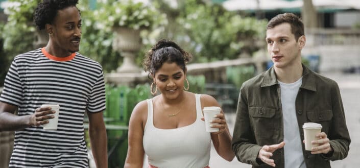 Three friends drinking coffee in park