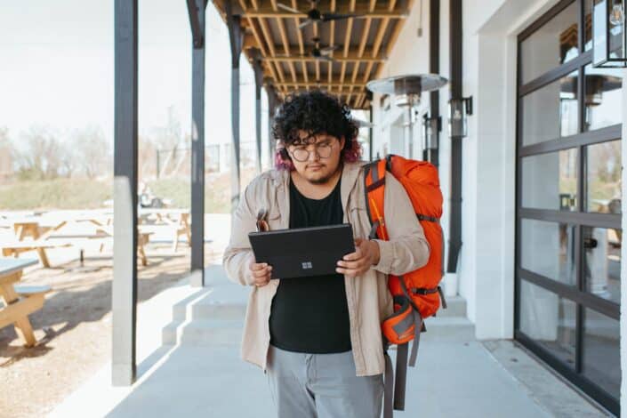 Man With Big Backpack Using a Tablet