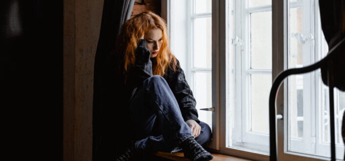 Woman in black leather jacket thinking