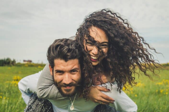 couple doing piggyride-back on field
