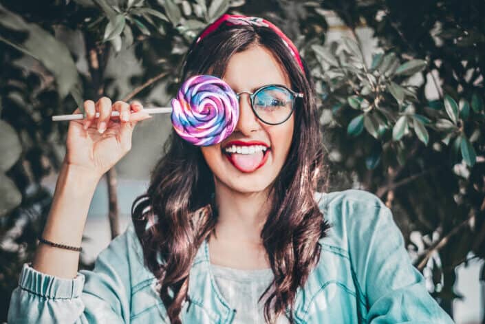 Woman in Green Jacket Holding a Lollipop