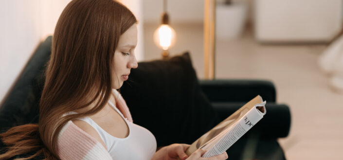 woman on couch reading a book