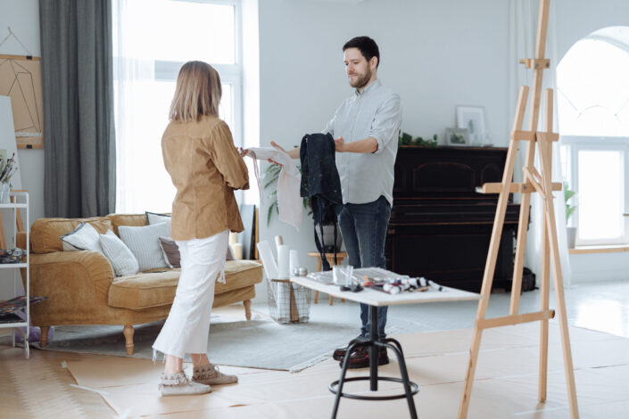 A man giving an apron to a woman
