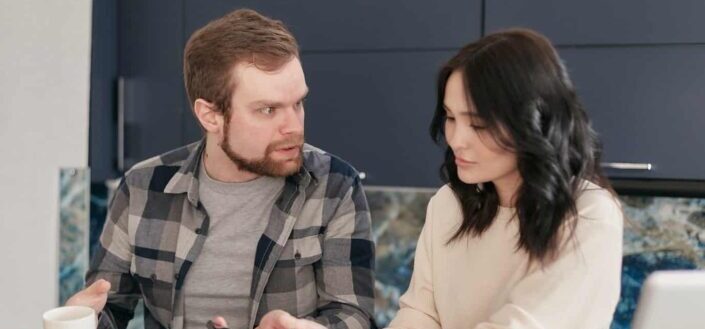 Man Glaring at a Girl While Sitting on a Bed