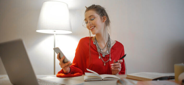woman in red longsleeve shirt using cellphone