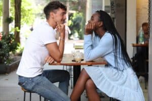 A man and woman sitting in a table looking at each other