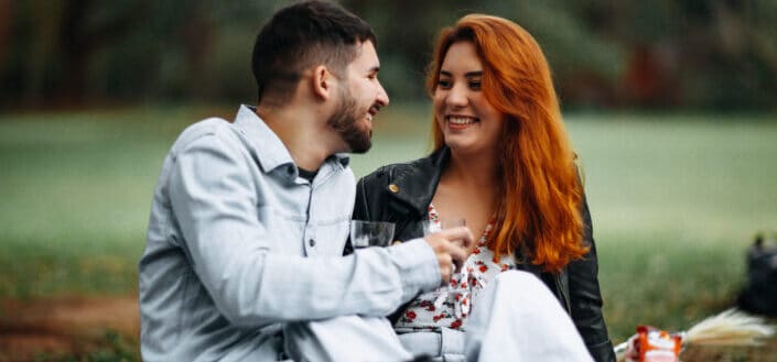 a couple drinking wine on the field