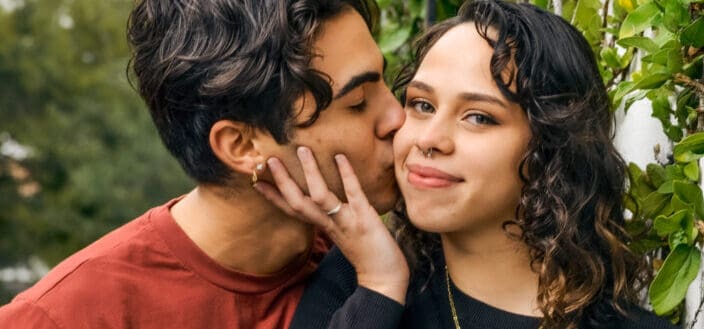 a man kisses his girlfriend on the cheek