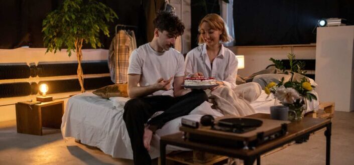 a man presents a cake to his girlfriend