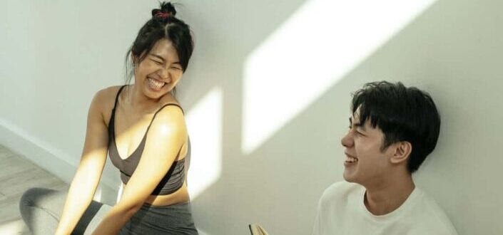 Cheerful couple sitting on floor