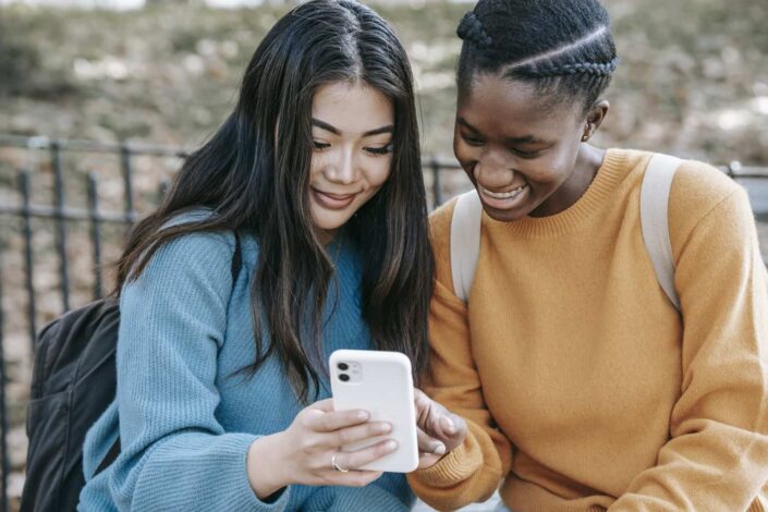 Cheerful Women Browsing Her Smartphone in Park