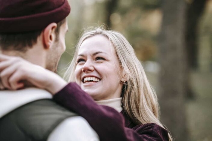 Cheerful woman embracing boyfriend in daylight