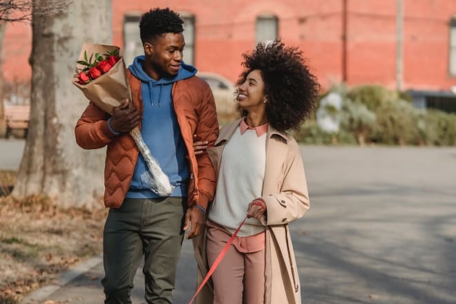 cute things to do for your boyfriend - Loving couple walking on sidewalk with dog