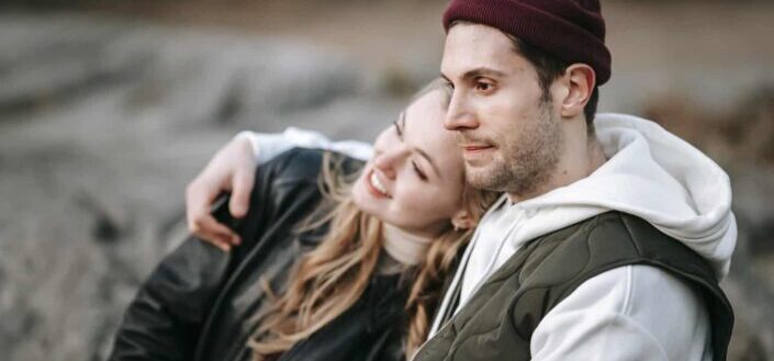 Dreamy man embracing charming girlfriend in daylight